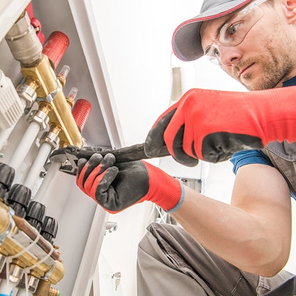 A plumber using a wrench on a pipe