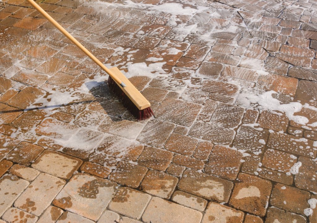 Nettoyer les pavés avec un balai à poils